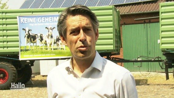 Michael Meeske, Geschäftsführer VfL Wolfsburg steht auf einem Bauernhof vor einem Anhänger. © Screenshot 