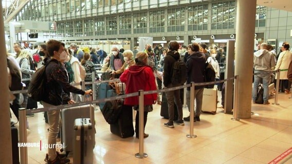 Menschen stehen in langen Warteschlangen im Abflugsterminal des Hamburg Airport. © Screenshot 