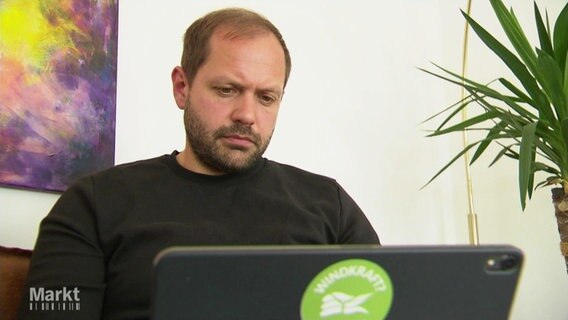 Ein Mann schaut auf den Bildschirm seines Laptops. © Screenshot 