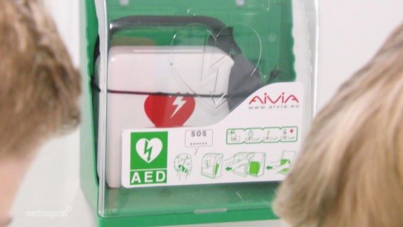 Ein Defibrillator hängt an der Wand. © Screenshot 