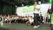 Football players of the Wolfsburg Football Club celebrate two titles on stage with their fans © Screenshot 