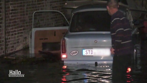Mann watet zu Auto in Wasser. © Screenshot 