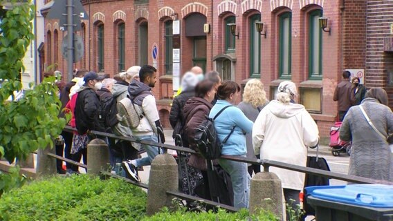 Menschen warten auf die Essensausgabe einer Tafel in Hamburg. © Screenshot 