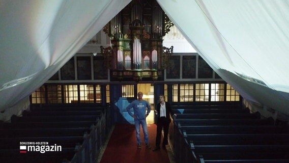 Zwei große Leinwände hängen von der Decke der Tatinger Kirche © Screenshot 