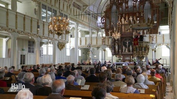 Im Innenraum der Kirche sitzen viele Besucher. © Screenshot 