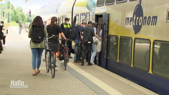 Menschen steigen in einen Zug der Bahngesellschaft Metronom ein. © Screenshot 