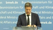 Bundeswirtschaftsminister Robert Habeck (Bündnis90/Die Grünen) steht bei einer Pressekonferenz hinter einem Rednerpult. © Screenshot 