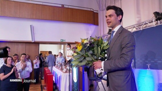 Christoph Ploß beim CDU-Landesparteitag in Hamburg mit einem Blumenstrauß in den Händen. © Screenshot 