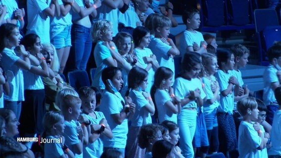 Viele Kinder im Grundschulalter stehen zusammen in der Barclays Arena in Hamburg. © Screenshot 