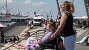 Eine Frau und ihre Tochter im Rollstuhl am Hamburger Hafen. © Screenshot 