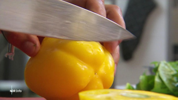 Ein Kochmesser schneidet eine Paprika. © Screenshot 