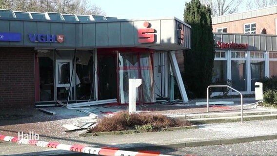 Blick auf den Eingang einer Sparkasse: zertrümmerte Glasscheiben liegen verstreut, der Innenraum ist verwüstet. © Screenshot 