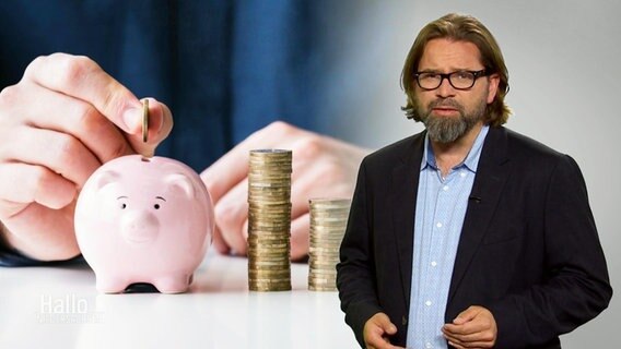 Journalist Marco Heuer steht vor einem Bild eines Sparschweins. © Screenshot 