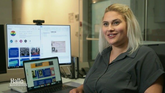 Eine junge Frau im Interview, im Hintergrund Computerbildschirme. © Screenshot 