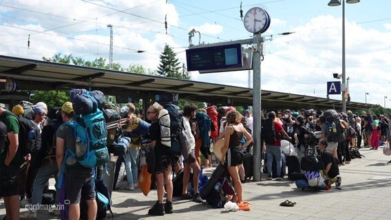 Besucher:innen des Fusion-Festivals warten auf den Zug nach Hause. © Screenshot 
