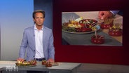 Moderator Jo Hiller bei Markt. Im Hintergrund eine Nahaufnahme verschiedener Tapas. © Screenshot 