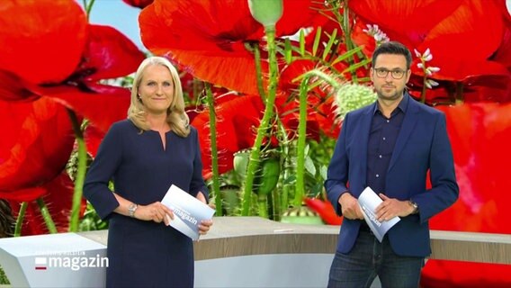 Harriet Heise und Christopher Scheffelmeier moderieren das Schleswig-Holstein Magazin. Im Hintergrund ein Bild von einer Klatschmohnwiese. © Screenshot 