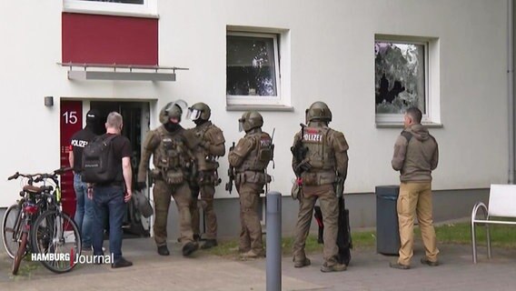 Uniformierte des Sondereinsatzkommandos der Polizei vor einem Wohnhaus. © Screenshot 