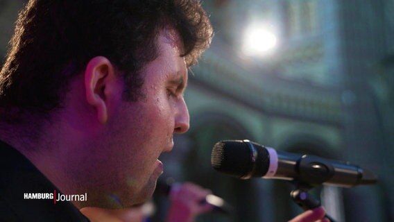 Ersin Gülcan singt in ein Mikrofon. © Screenshot 