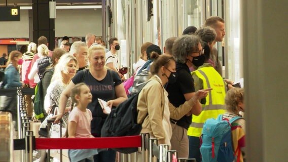 Menschen in einer Warteschlange am Hamburger Flughafen © Screenshot 