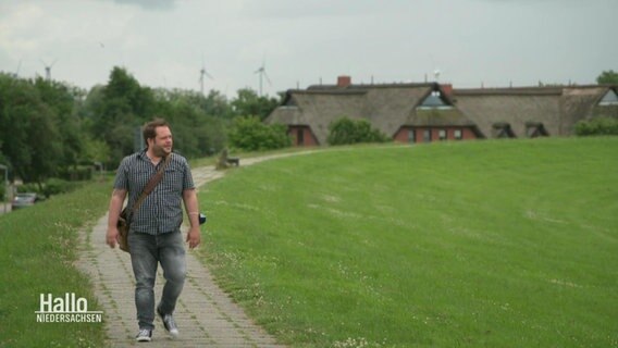 NDR Reporter Jan Bockemüller geht auf einem Deich spazieren und schaut in die Ferne. © Screenshot 