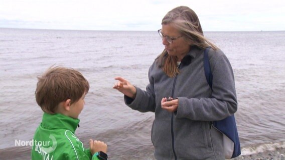 Eine Frau mit einem Bernstein in der Hand. © Screenshot 