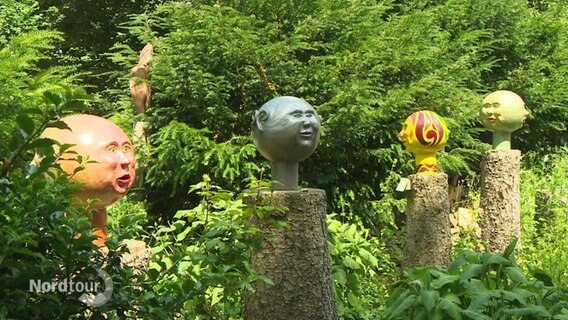 Kunstfiguren in einem Garten. © Screenshot 