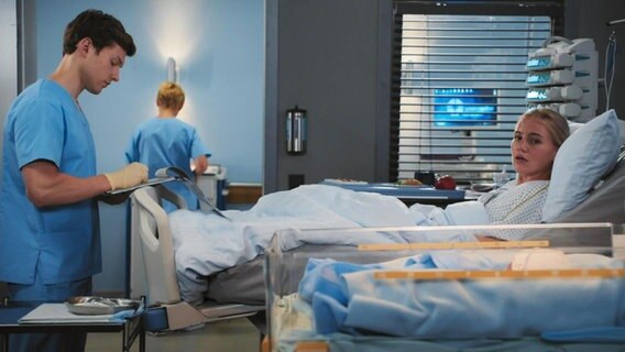 Eine junge Frau liegt in einem Krankenhaus-Bett und schaut zu einem Babybett herüber. © Screenshot 
