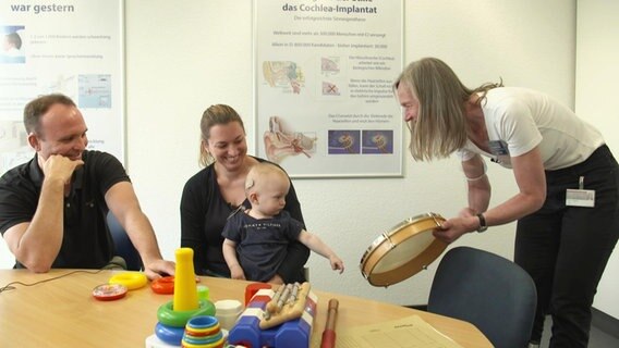 Ein Baby trägt ein Cochlea-Implantat am Kopf. © Screenshot 