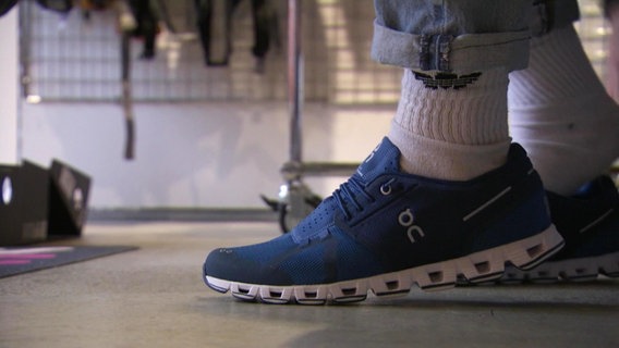 Eine Person trägt einen Sneaker am Fuß. © Screenshot 