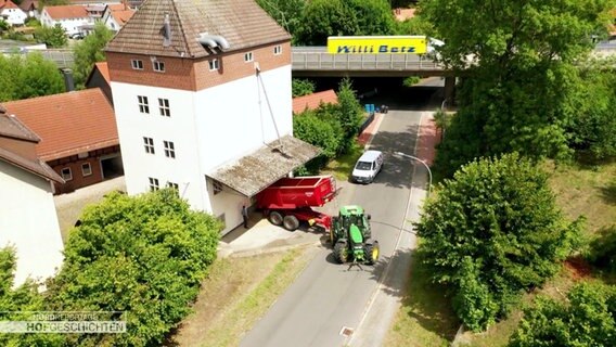 Vor einem Getreidesilo steht ein Erntefahrzeug mit Hänger. © Screenshot 