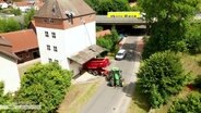 Vor einem Getreidesilo steht ein Erntefahrzeug mit Hänger. © Screenshot 