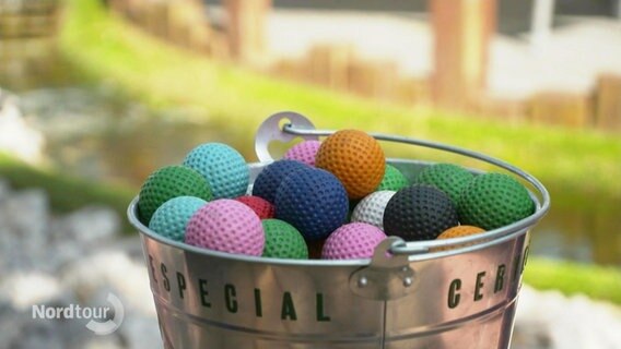 Bunte Golfbälle in einem Eimer. © Screenshot 