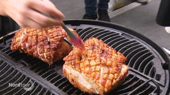 Auf einem Grill liegendes Fleisch wird bepinselt. © Screenshot 