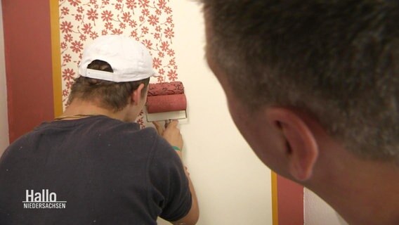 Auf eine Wand werden Blumenmuster mit Farbe angebracht. © Screenshot 