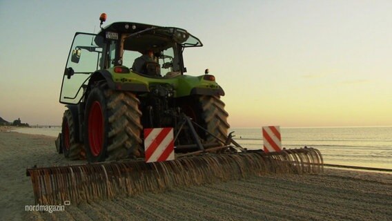 Ein Traktor glättet bei Sonnenaufgang den Strand. © Screenshot 