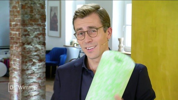 Dr. Wimmer hält eine Faszienrolle in der Hand. © Screenshot 