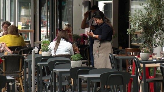 Eine Kellnerin nimmt eine Bestellung auf. © Screenshot 