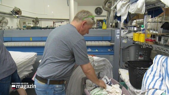Ein Mann arbeitet in der Wäscherei. © Screenshot 