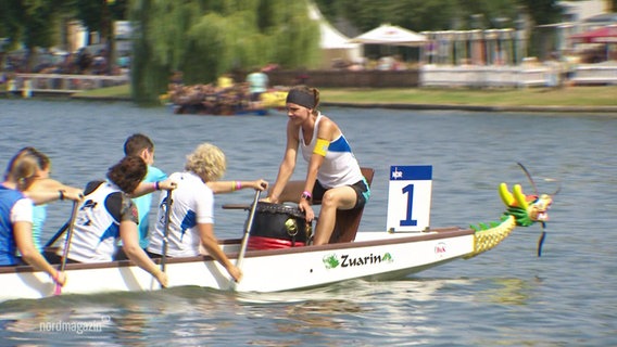 Ein Boot mit Teilnehmenden beim Drachenbootfestival in Schwerin. © Screenshot 