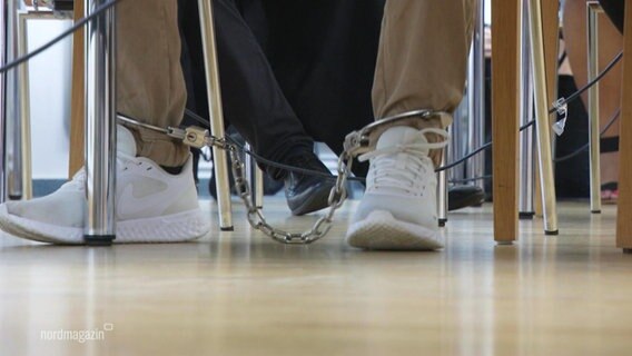 Die Füße eines Angeklagten in Ketten. © Screenshot 