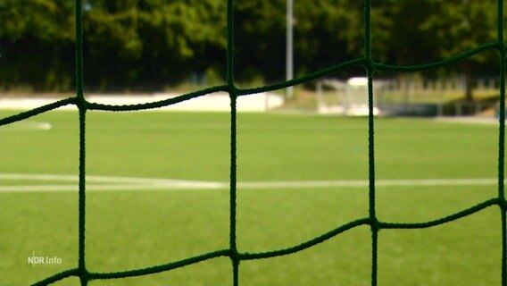 Ein Sportplatz durch ein Tornetz betrachtet. © Screenshot 
