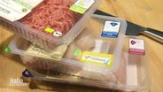 Nahaufnahme von drei übereinander gestapelten Fleischverpackungen mit unterschiedlichen Tierwohl-Labeln. © Screenshot 