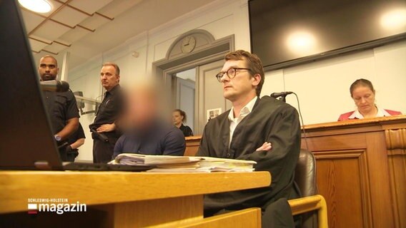 Ein Mann mit unkenntlich gemachten Gesicht in einem Gerichtssaal. © Screenshot 