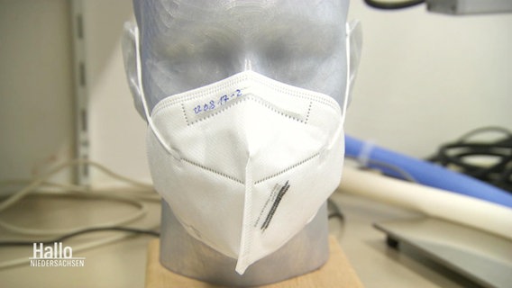Eine Kopf aus Kunststoff trägt eine weiße FFP2-Maske. © Screenshot 