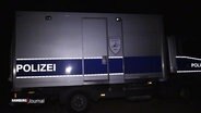 In der Dunkelheit steht ein Einsatzfahrzeug der Hamburger Polizei für Sprengstoff-Entschärfungen. © Screenshot 