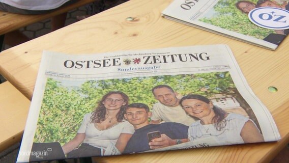 Auf einem Holztisch liegen zwei Exemplare der "Ostsee-Zeitung". © Screenshot 