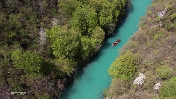 Blick aus der Vogelperspektive auf ein Holzfloß das auf dem türquisblauen Wasser des Flusses Tara in Montenegro schwimmt. © Screenshot 