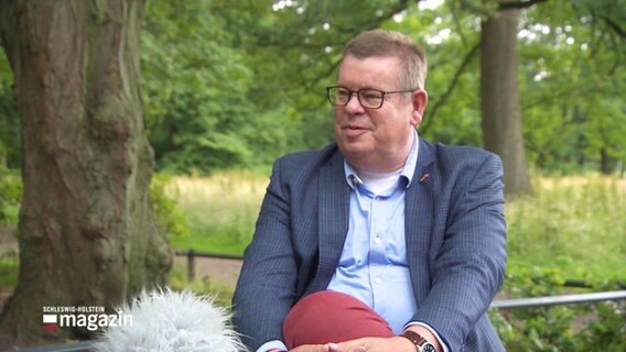 Norwegens Honorarkonsul Arno Witt gibt im Park ein Interview. © Screenshot 