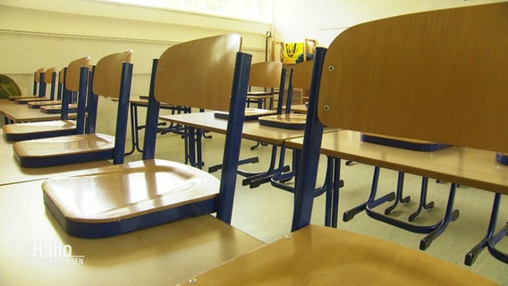 Ein leeres Klassenzimmer mit hochgestellten Stühlen © Screenshot 